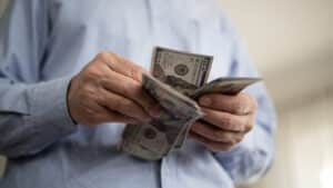 Adult man counting dollars at home