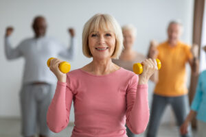 Senior lady doing strength building workout with dumbbells