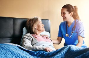 Assisted living, bedroom or retirement with nurse and old woman in home for private healthcare. Medical, smile and support with senior patient or resident with medicine professional in apartment